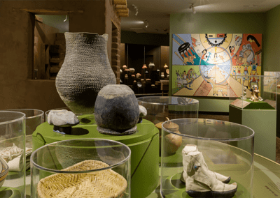A display of historic artifacts, including pottery and ancient vessels, at a Native American tribal museum in New Mexico.