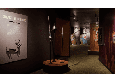 A display of objects at a Native American museum that includes Spanish armor and a text panel that reads, Strength to Overcome.