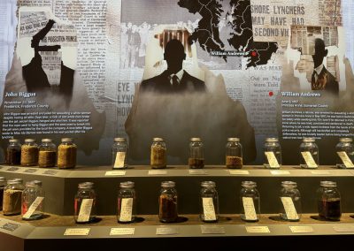 A haunting interactive screen that shows the silhouettes of people juxtaposed with newspaper articles and maps.