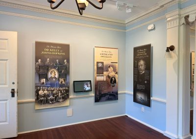 Panels about Dr. Kelly of Johns Hopkins in a historic house museum room with light blue walls.