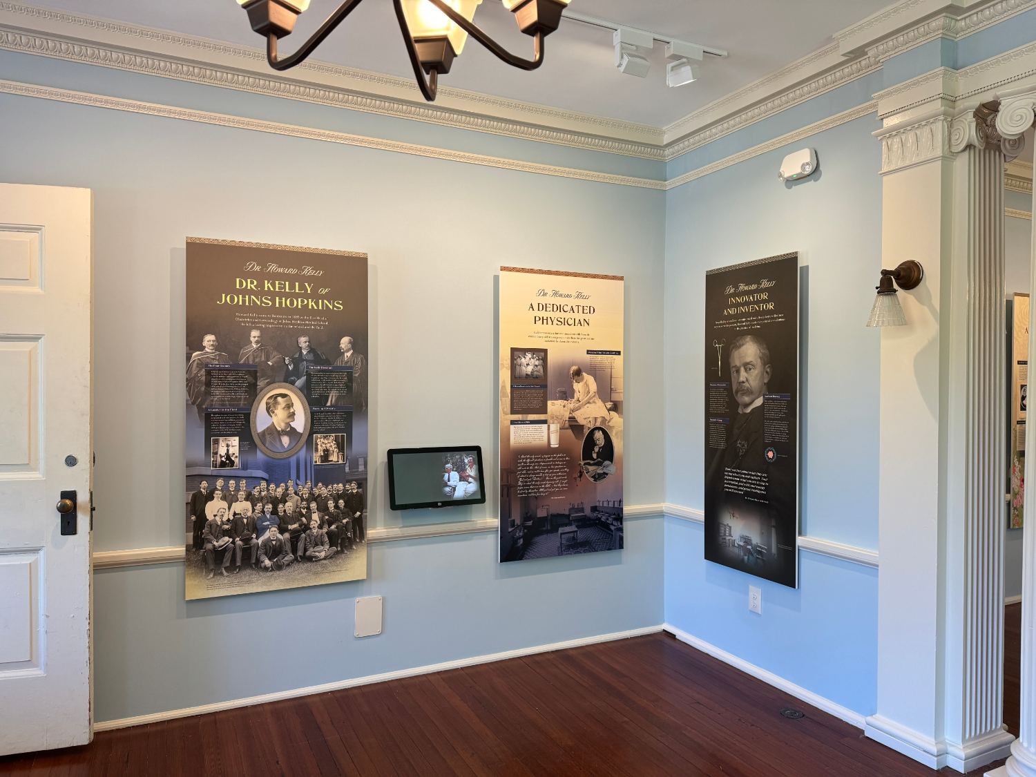 Panels about Dr. Kelly of Johns Hopkins in a historic house museum room with light blue walls.