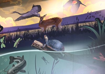 A close up of a mural that shows a deer, a turtle, and a heron.