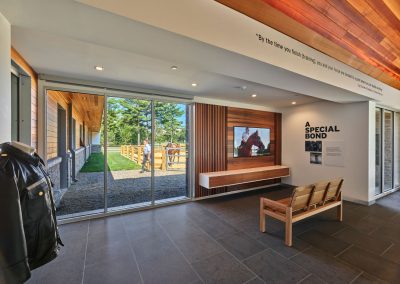 An interior space with a slate floor, a wooden bench, and a leather jacket on the wall.