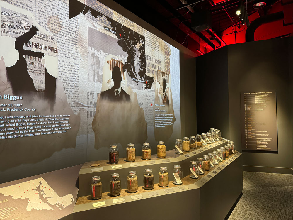 A large multimedia project with various clips from old newspapers. In the foreground are jars of dirt on a two separate shelves.