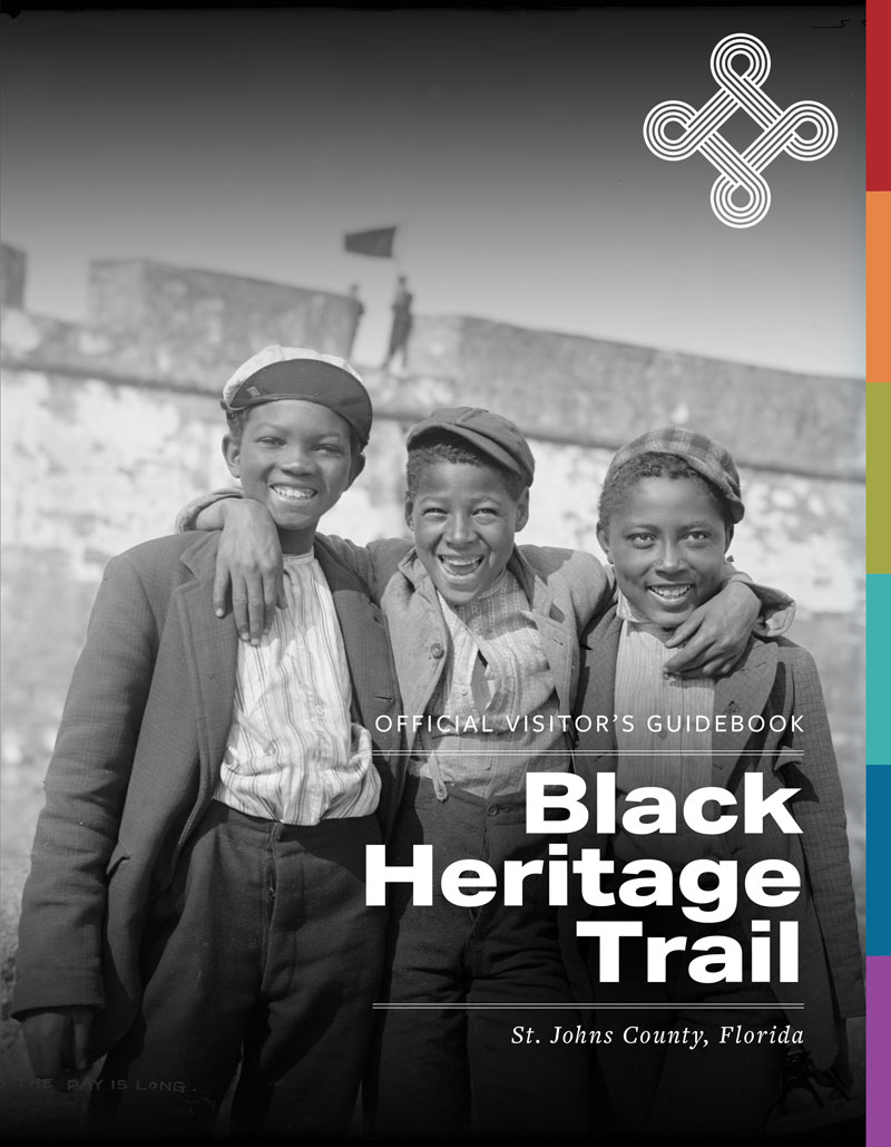 The cover of a publication with three young boys from the 1930s standing in front of a stone fort. 
