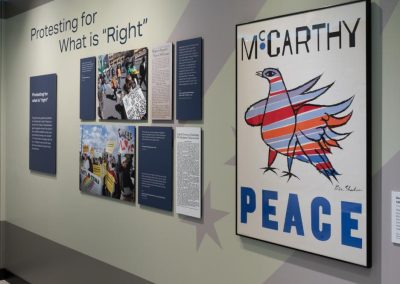A wall of art and text in a museum that talks about protest and peace.